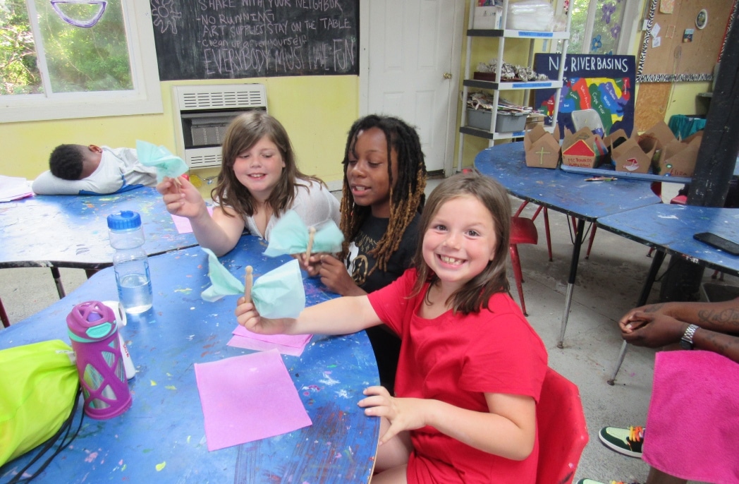 Children at a camp work on arts and crafts.
