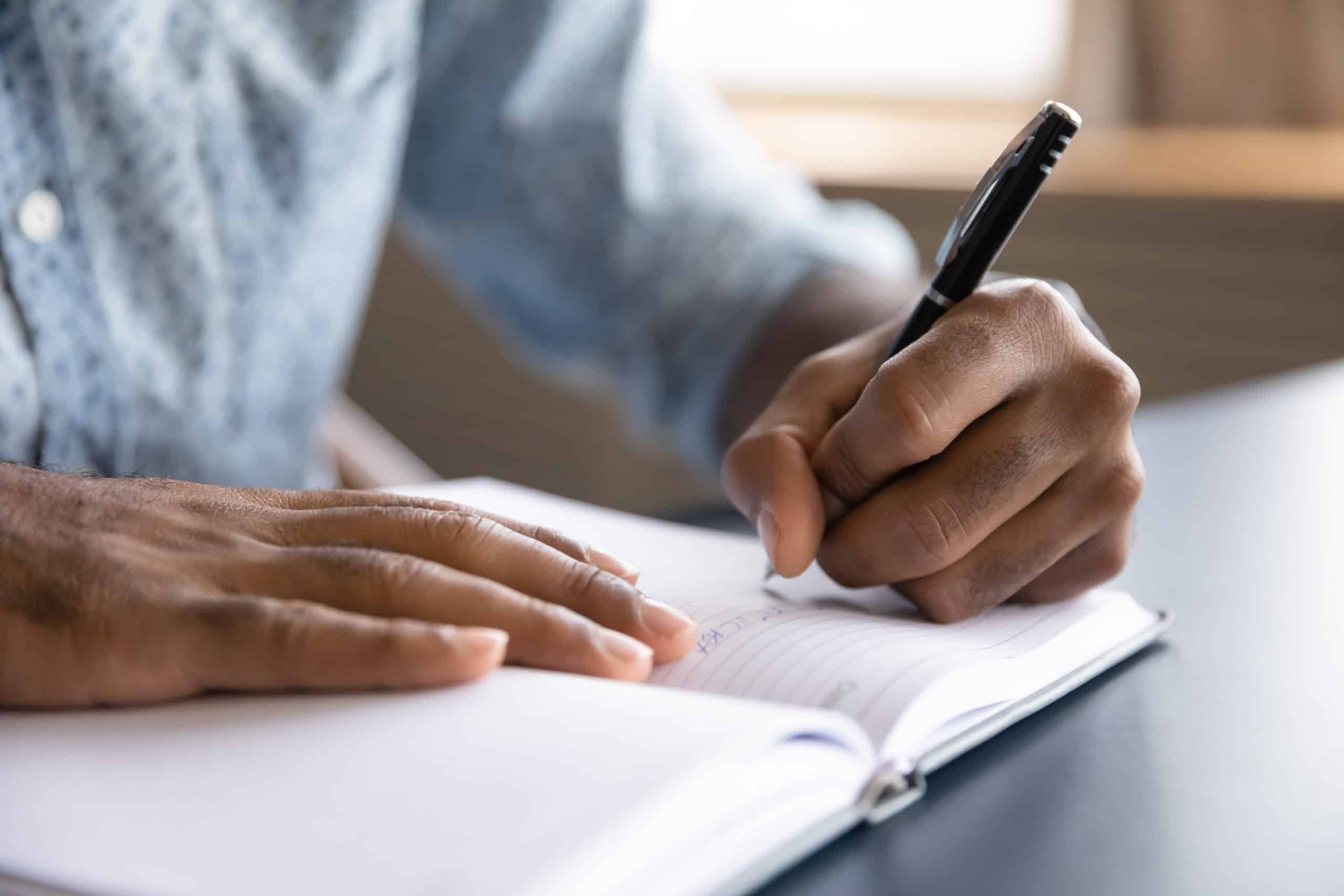 Close up view of a person journaling in a notebook.