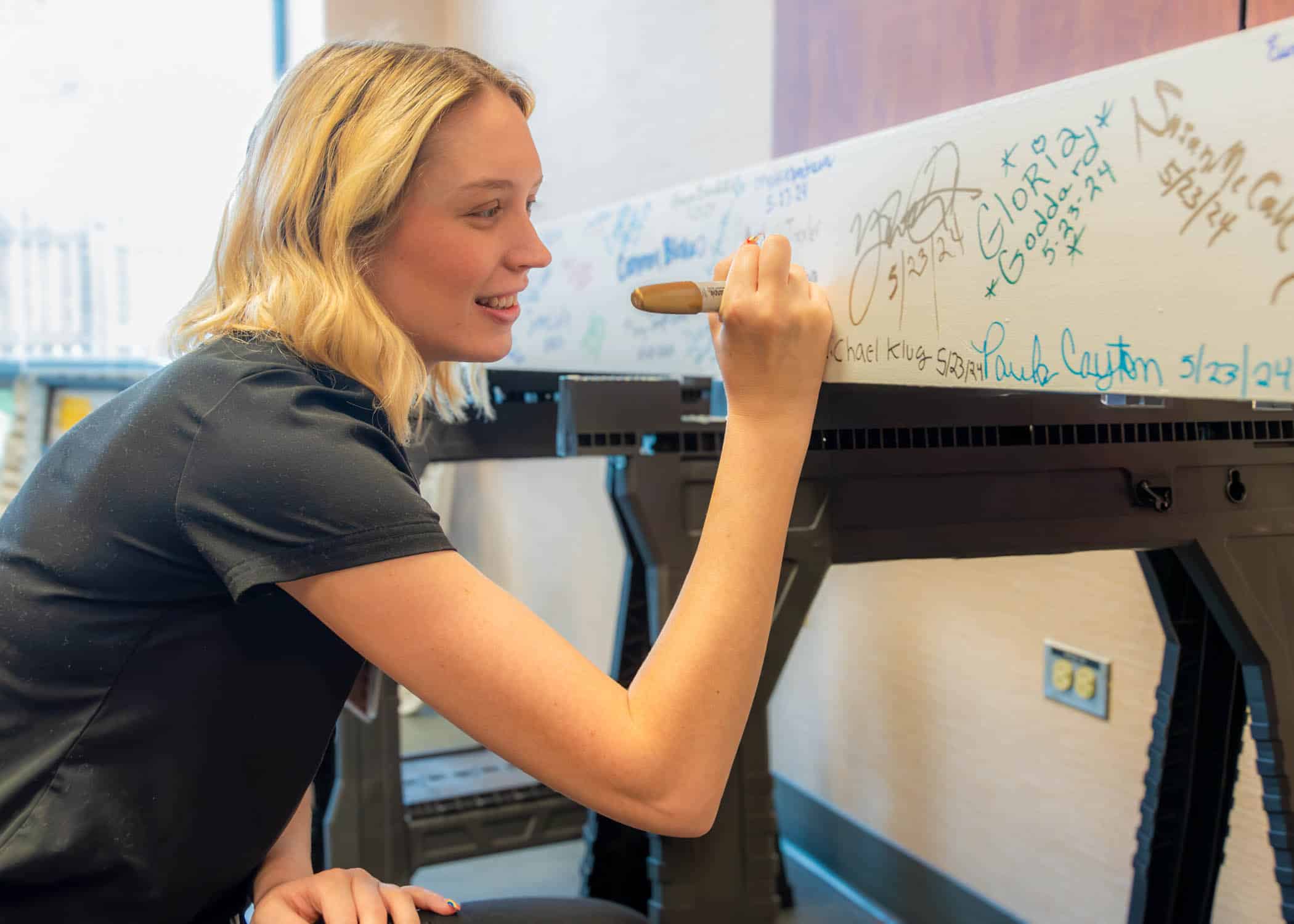 ECU Health behavioral health nurse Samantha Nichols signs the beam that is slated to go inside of the new behavioral health hospital.