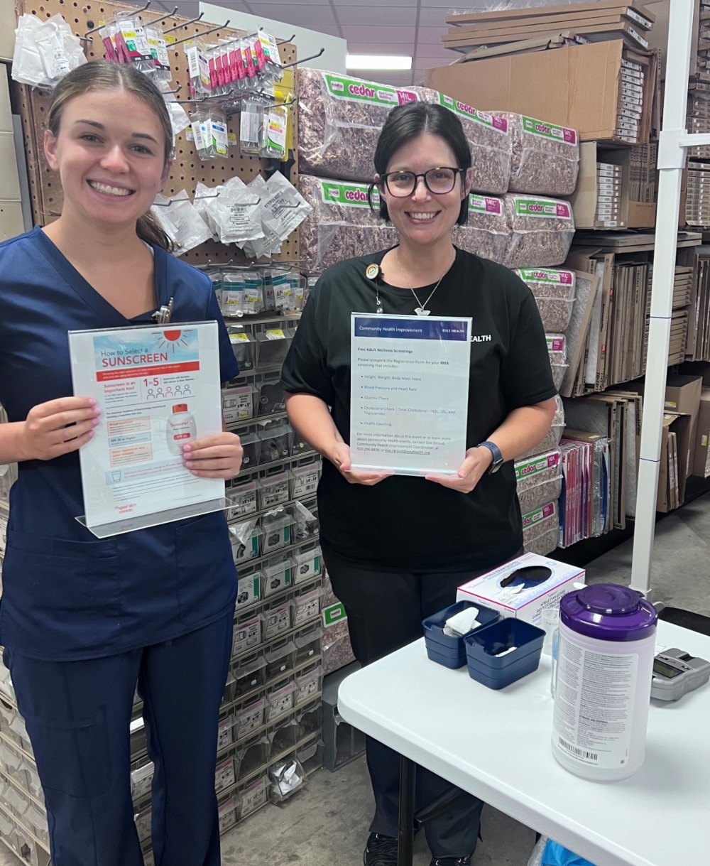 Two ECU Health team members pose for a photo inside of a hardware store in eastern North Carolina, where they shared information on skin cancer risks and safety tips.