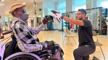 A Rock Steady Boxing Program participant works with an ECU Health team member during a training session.