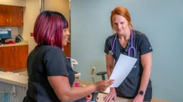 Two ECU Health nurses discuss a patient's care at ECU Health Medical Center.