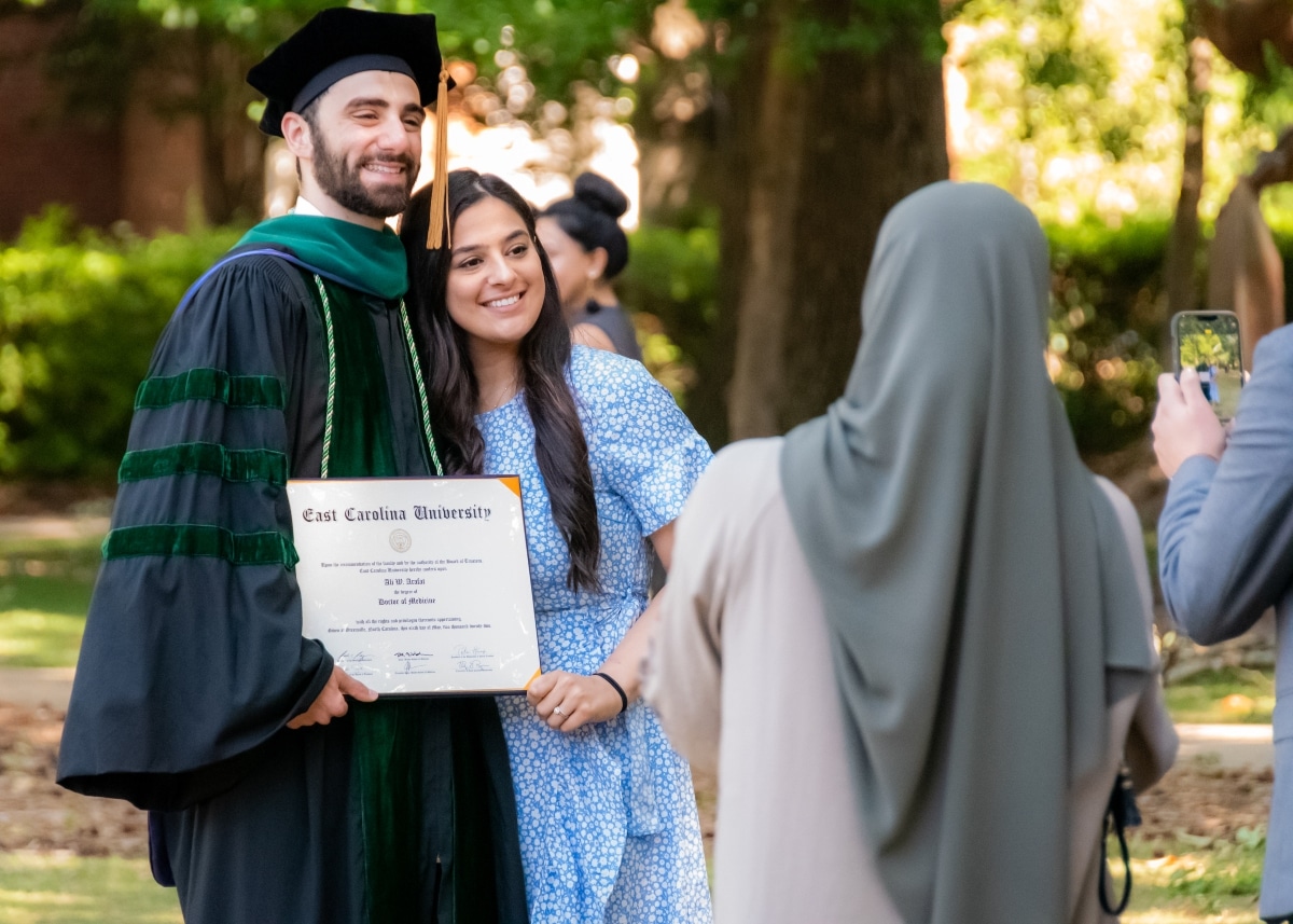 A Brody School of Medicine 2022 graduate poses for a photo with their family.