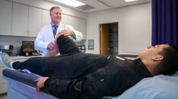 Dr. Christopher Hasty performs a knee exam.