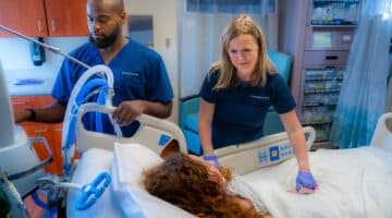 Members of ECU Health Medical Center's Respiratory Care team meet with a patient.