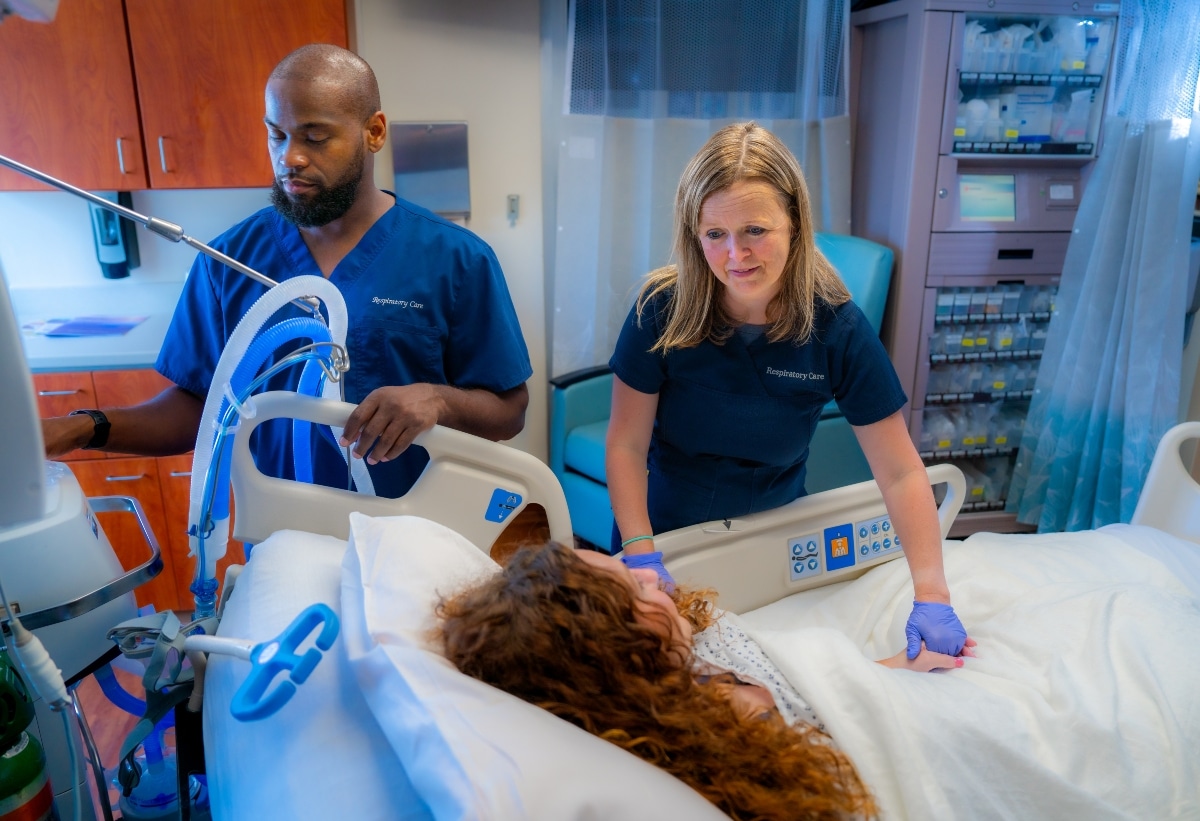 Members of ECU Health Medical Center's Respiratory Care team meet with a patient.