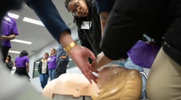 Daria Dancy, a senior at Roanoke Rapids Early College in Halifax County, watches closely as a fellow high school student under the direction of a Brody School of Medicine student practices basic life support during a simulation. (Photos Courtesy of ECU News Services)