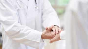 A doctor shakes hands with a patient.