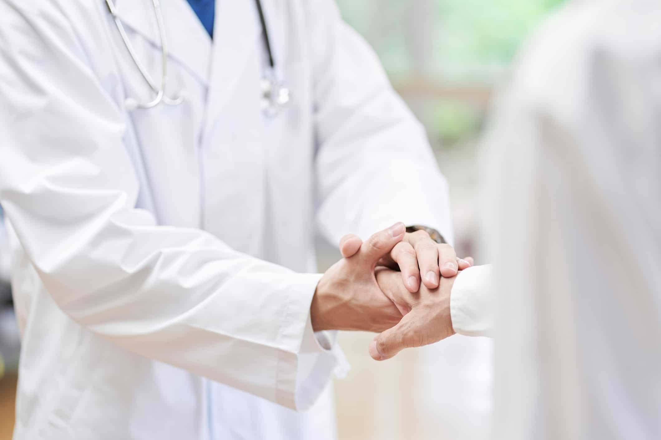 A doctor shakes hands with a patient.